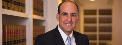 Photograph of Ed Tancer with law books in the background